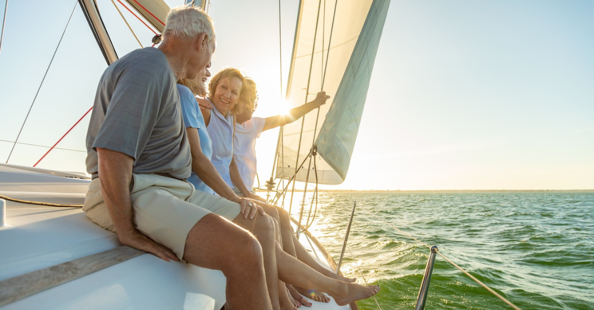 group of adult friends on sailboat dangling their feet